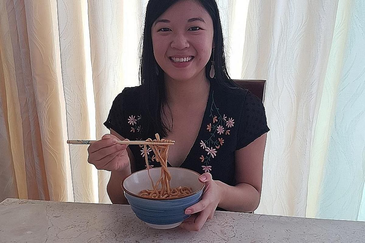 The reporter trying noodles for her review of five brands available here. Twin sisters Gay (far left) and Gertie Buen of Redwagon Holdings introduced Taiwanese air-dried noodle brand A-Sha to the Singapore market a few weeks ago, after Ms Gay Buen tr