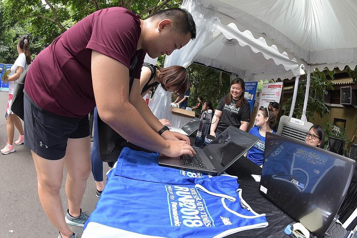 Visitors to The Straits Times Concert in the Gardens signing up yesterday for the ST Run that will be held on Sept 23. They received exclusive ST Run 2018 premiums - a cotton tote bag, a towel and a special water bottle with a misting feature. Childr
