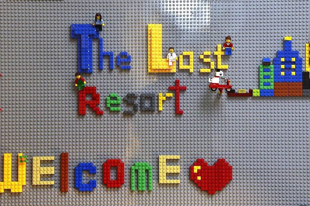 A sign in the living room made from Lego bricks. Most of the young people who come to the Thongs are from abusive and dysfunctional families. Above: The Thongs (standing) serving a meal to guests, who included residents of their home, volunteers and 