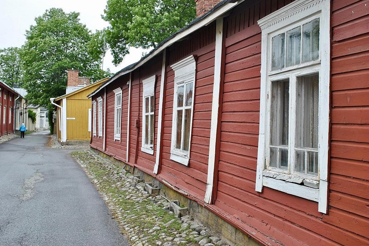 Peterzens Boathouse Hotel has cosy waterfront cabins. Naantali (above) has historic houses built from wooden planks and painted pastel colours. The writer and her family (left) cycled through the Turku Archipelago in Finland.