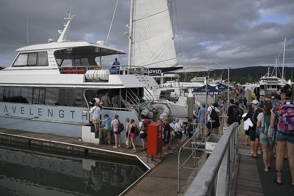 At Port Douglas, tourists board their boats for cruises out to the Great Barrier Reef for diving or snorkelling.