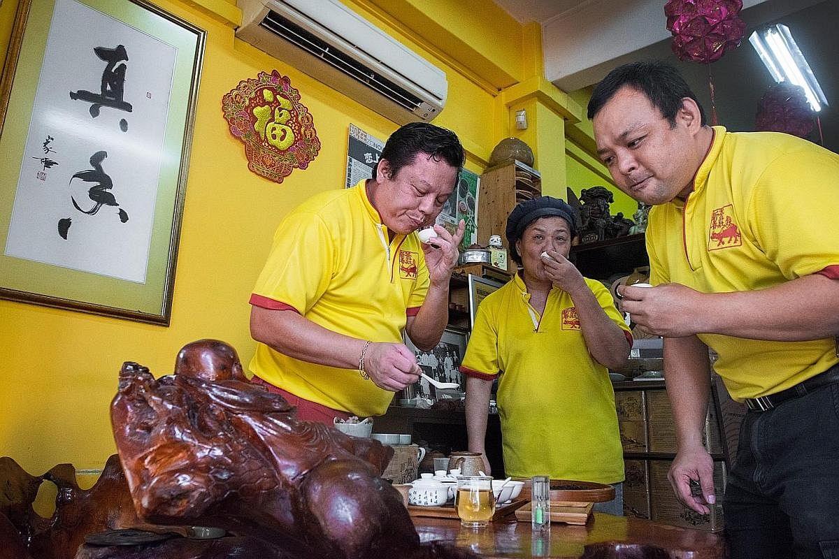 (From left) Mr Kenry Peh, 49, a fourth-generation "teaman" or owner, is joined by his cousin Peh Hong Kee, 54, and another employee Yuen Eng Wah, 48, during the sampling process to determine whether the tea is up to standard.