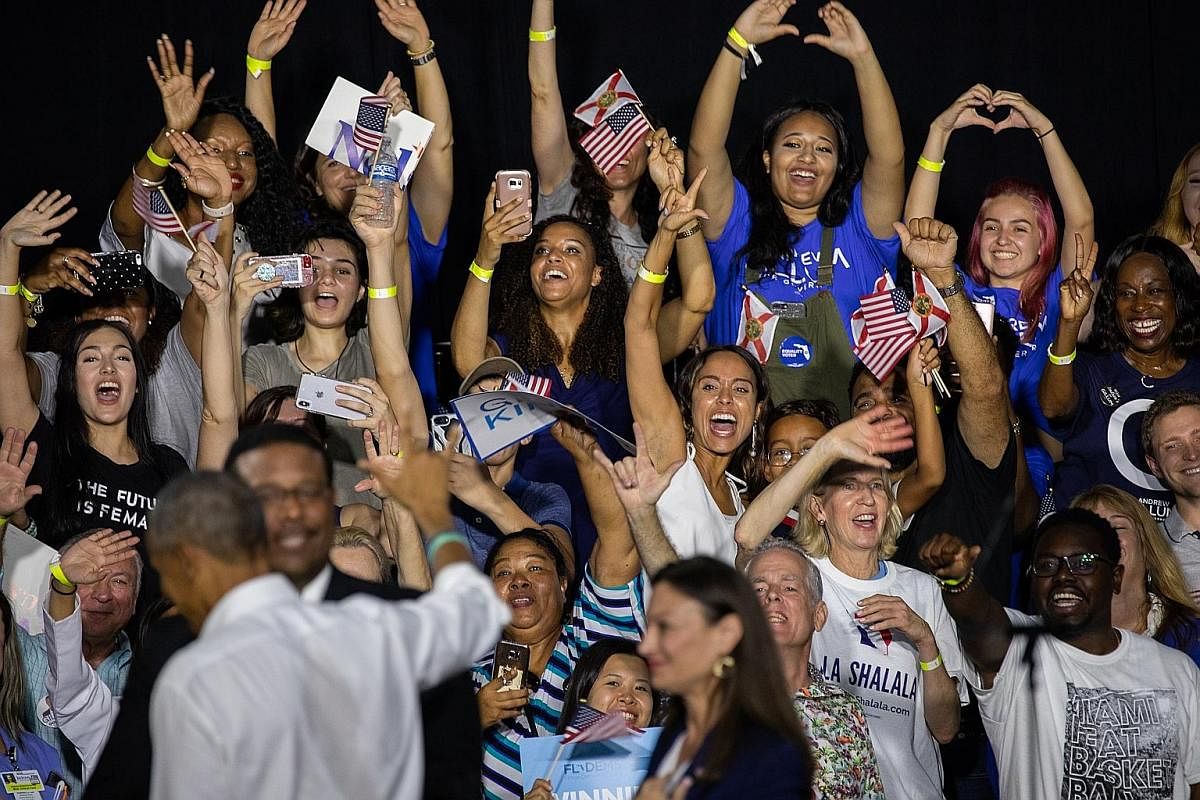 Former US president Barack Obama (back to camera) waving to the crowd after speaking at a rally for Florida's Democratic candidates Andrew Gillum and Bill Nelson in Miami last Friday, ahead of today's midterm elections. Trump supporters waiting in li