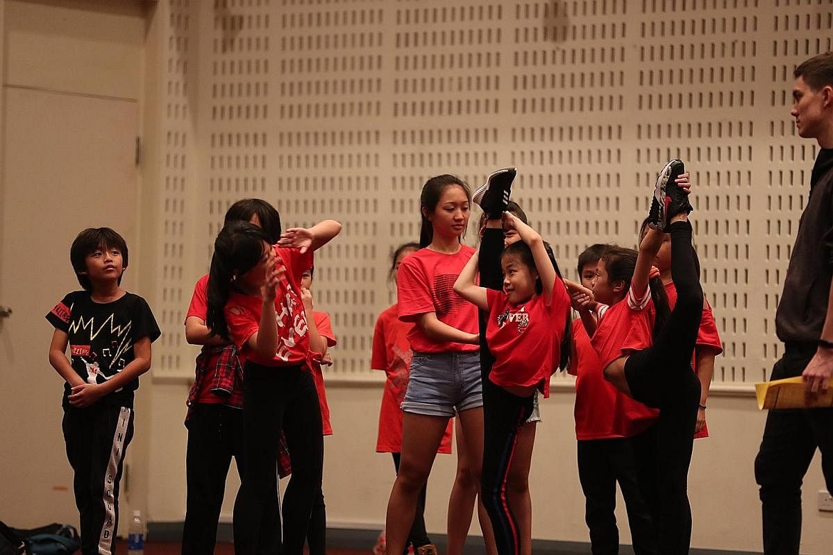 Some performers stretching out on Nov 11, one of the combined rehearsal sessions for ChildAid 2018. Performer Adriana Balqis (left), nine, touching up the make-up of fellow performer Chloe Wong Yu Xuan, eight, before the full-dress rehearsal yesterda
