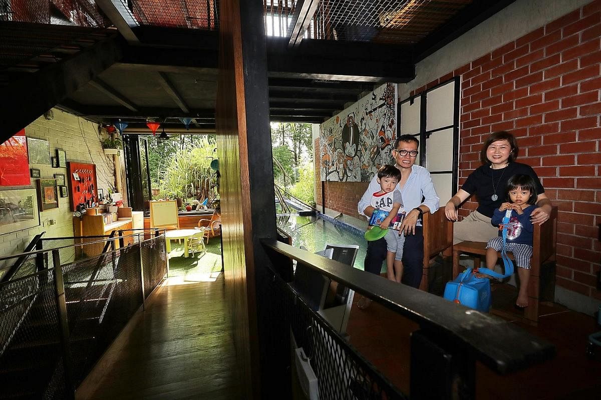 An open-concept design (above) encourages plenty of cross-ventilation in the intermediate terrace house of Mr Randy Chan and his wife Jancy Rahardja (left, with their children Zachary and Ariel).