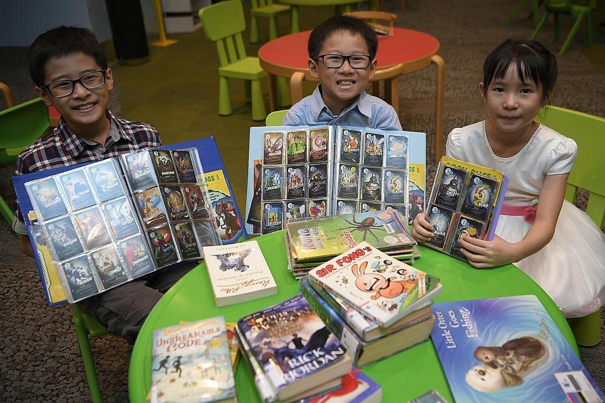 Ilika Motani, 10, and her brother, Darshan Motani, six, are avid Book Bugs card collectors. Lucian Lee, eight, and Lukas Lee, four, with their parents, Ms Chanelle Lim and Mr Larry Lee, taking part in a National Heritage Board's Heritage Explorers Pr