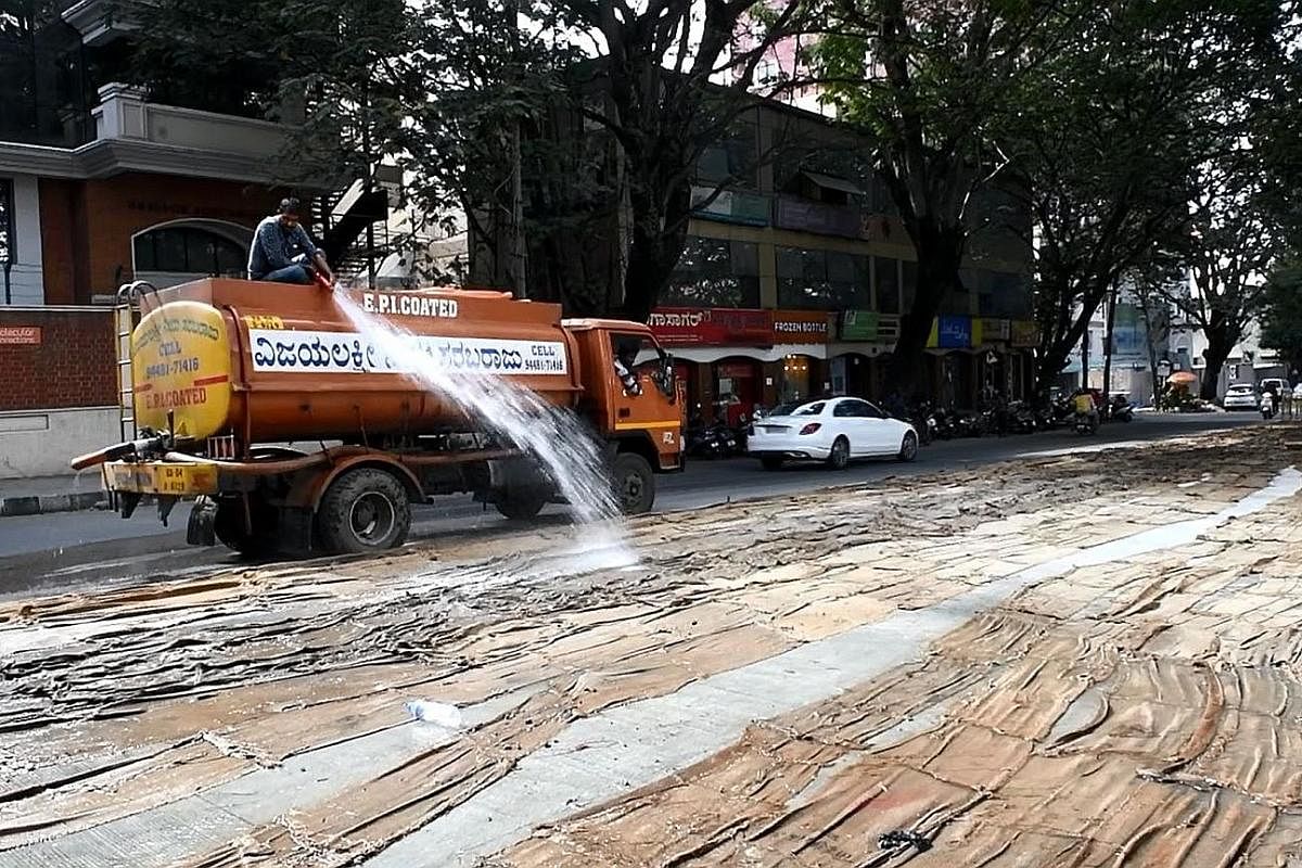 A private tanker spraying water on a road being built in Bengaluru, the capital of Karnataka. There is bitterness in the Indian state over the perceived unfairness of how water is distributed. Residents in the Indian capital New Delhi filling their c