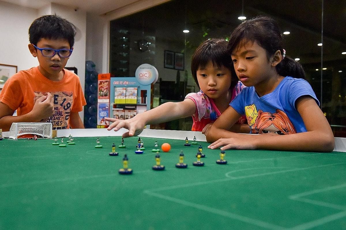Isaac Lim (at left), 13, playing a friendly game with his father Bernard Lim, 46, while his brother Luke (face hidden), 15, acts as the referee. Memorabilia from over 10 years of competitions, these old Subbuteo footballs are now too brittle to play 