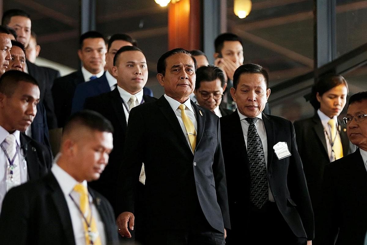 Dr Uttama Savanayana (above) says it would be ideal if Prime Minister Prayut Chan-o-cha (with yellow tie in middle picture) gets to keep his job after the Feb 24 general election. People waiting to withdraw government-allotted cash handouts recently 