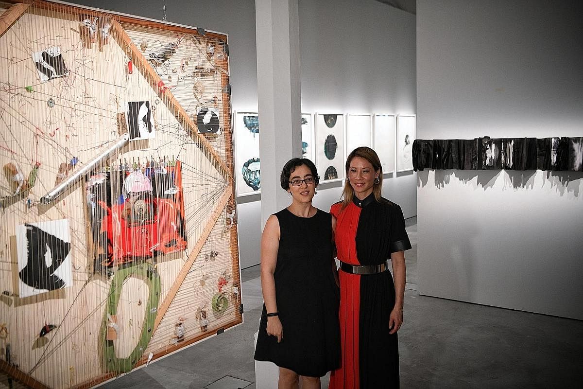 APB Foundation Signature Art Prize Jurors' Choice Award recipient Shubigi Rao (left) and Hollywood actress and artist Lucy Liu at their joint exhibition, Unhomed Belongings, at the National Museum of Singapore. These shelves hold handmade books from 