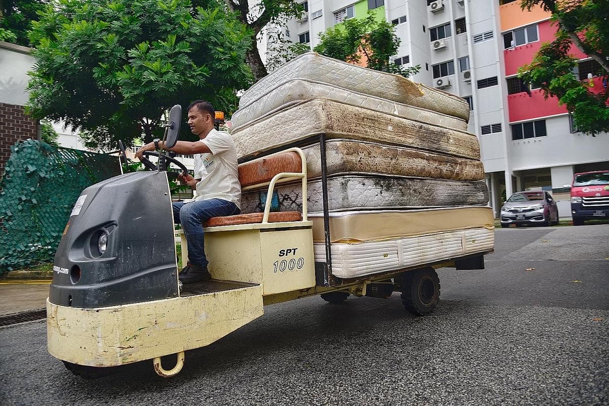 Junior college student Chow Xin Tian has been using the Renew bins at StarHub for her used computer parts and electronic products. A worker from Nee Soon Town Council drives a battery-operated cart with discarded mattresses to a bin centre in Yishun 