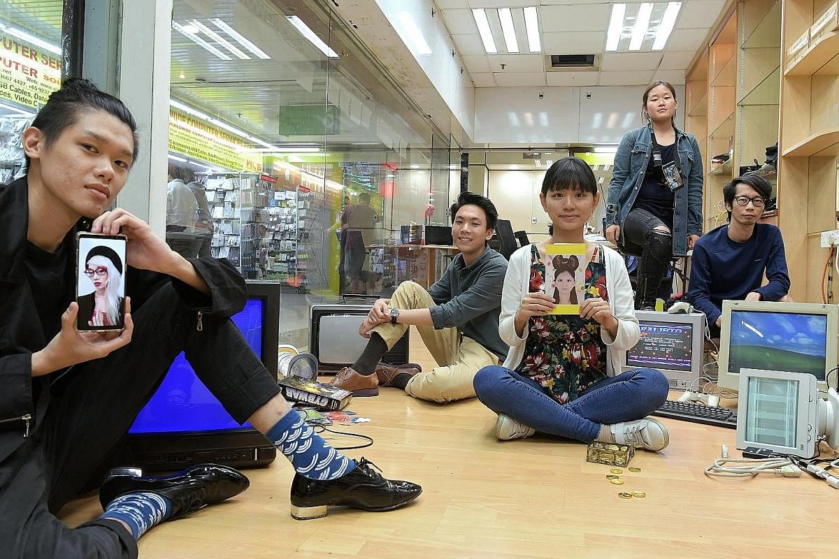 Artist assistant Jovan Tng (far left) holds up an image of Singaporean artist Chong Weixin, who is participating virtually in the Sim Lim Square Art Residency by art collective Inter-Mission. Also taking part are (from left) Singaporean artist Johann