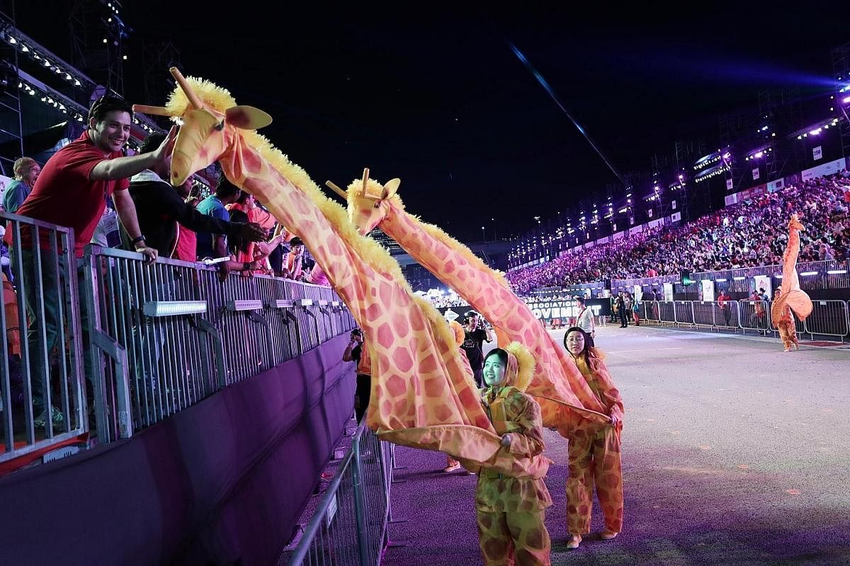 Right: A member of the audience interacting with a "giraffe" on the move. The act was presented by martial arts academy Martial House. Far right: Cambodian performers showcasing their classical and contemporary dance moves. Left: A member of the Nort