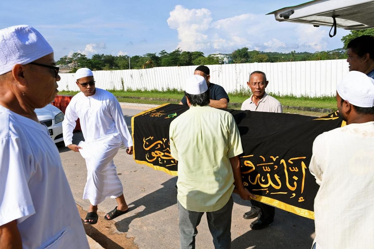 Mr Razaly helping other undertakers carry a body from the hearse to the burial grounds during the Jenazah Management Course. He sees his work as a learning journey because he says every death he handles is different.