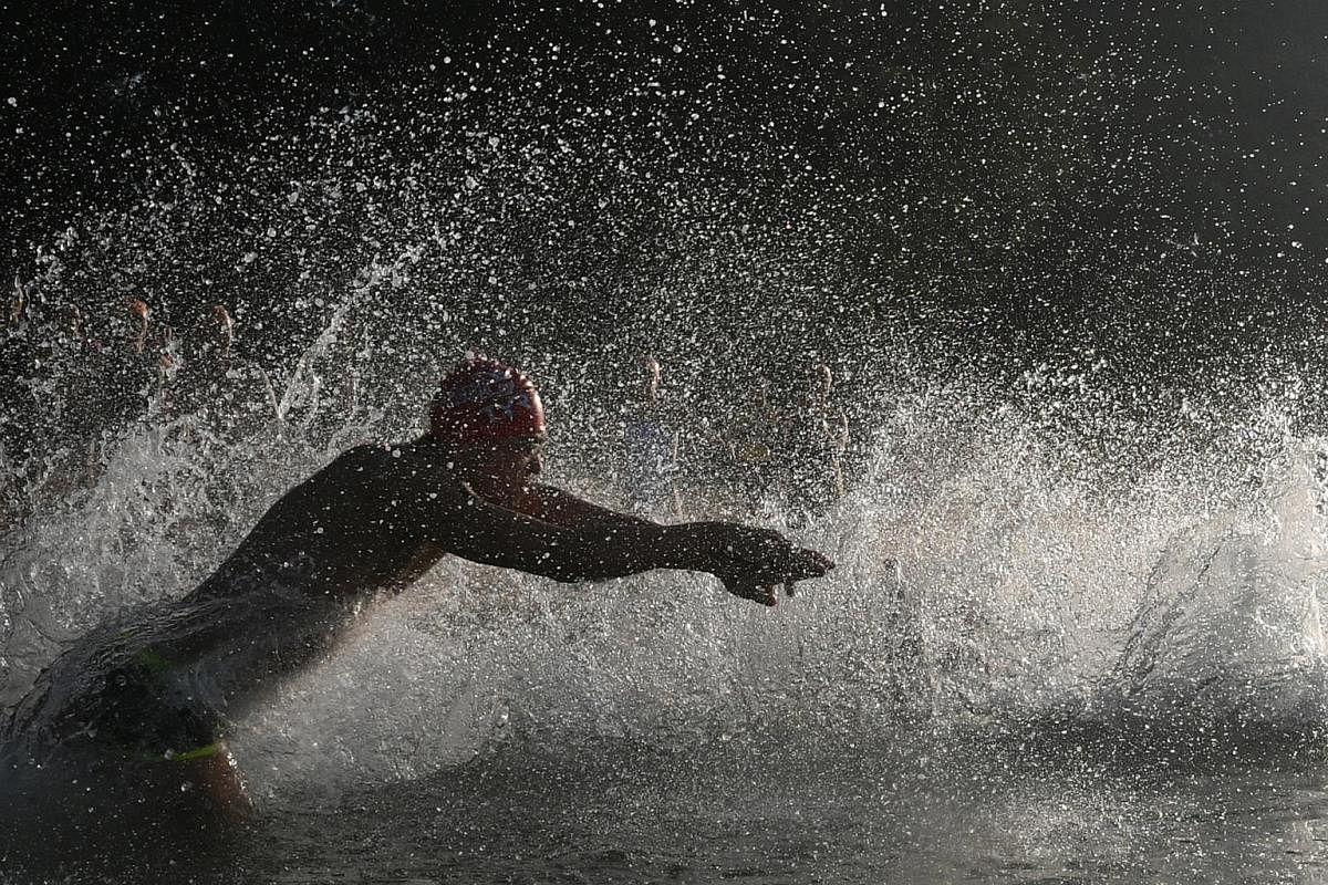 Right: A boy playing under a curtain of water falling from orchid-shaped splash buckets at the Waterplay area at the Far East Organization Children's Garden at Gardens by the Bay. Far right: A participant at the TRI-Factor Series triathlon held at th