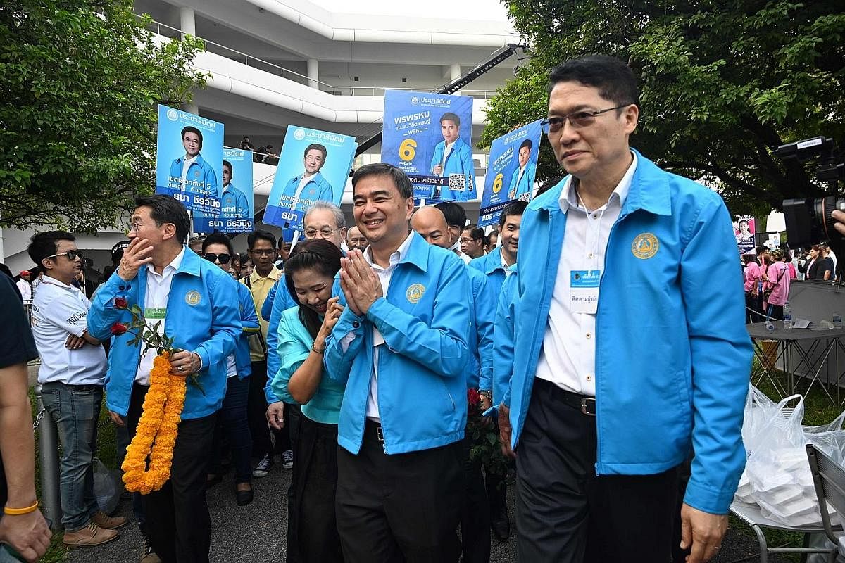 The Palang Pracharath's leader, Mr Uttama Savanayana (centre), with the pro-junta party's parliamentary candidates in front of a picture of Prime Minister Prayut Chan-o-cha at an election campaign last week. Students overcome with excitement as Mr Th