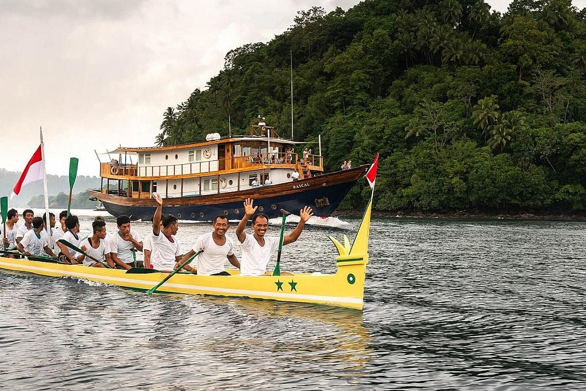 A kora kora races the Rascal, a phinisi yacht, out of the harbour at Banda Neira. Traditionally a war boat, the kora kora is now used for ceremonial purposes and in an annual race.