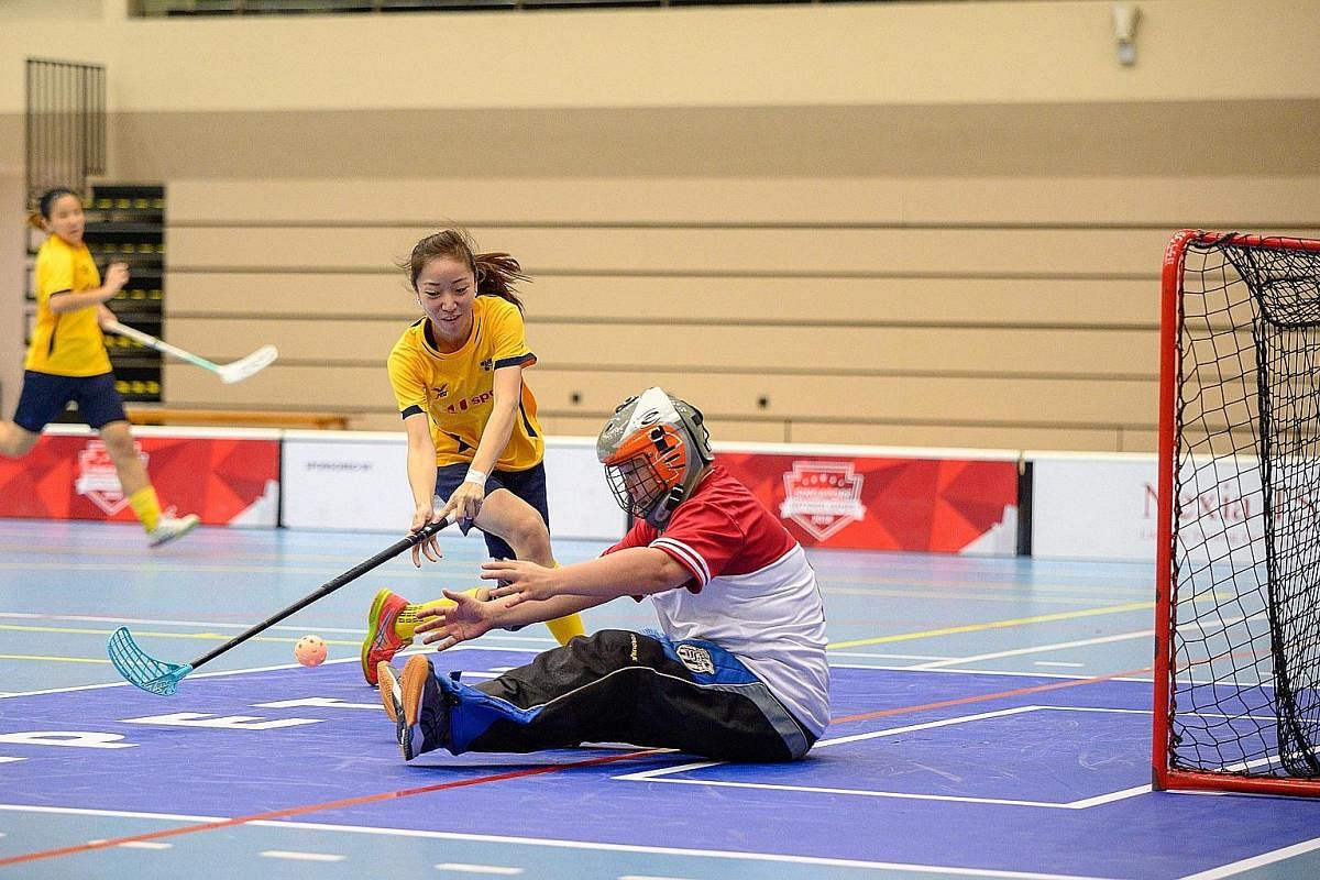 Joan Hia of Team U Sports Litto FC trying to score past Team Tempest goalkeeper Neo Chien Jun in their ActiveSG-SFA Floorball Premier League opener at Our Tampines Hub yesterday. Team U Sports Litto won 10-0. The first round of the league, which feat