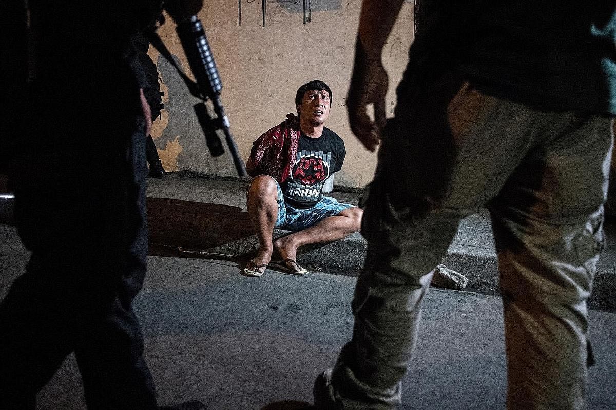 Male residents being rounded up for verification after police officers conducted a large-scale anti-drug raid in a slum community in Manila in July 2017. One resident was killed in the raid, according to police. Philippine Drug Enforcement Agency age