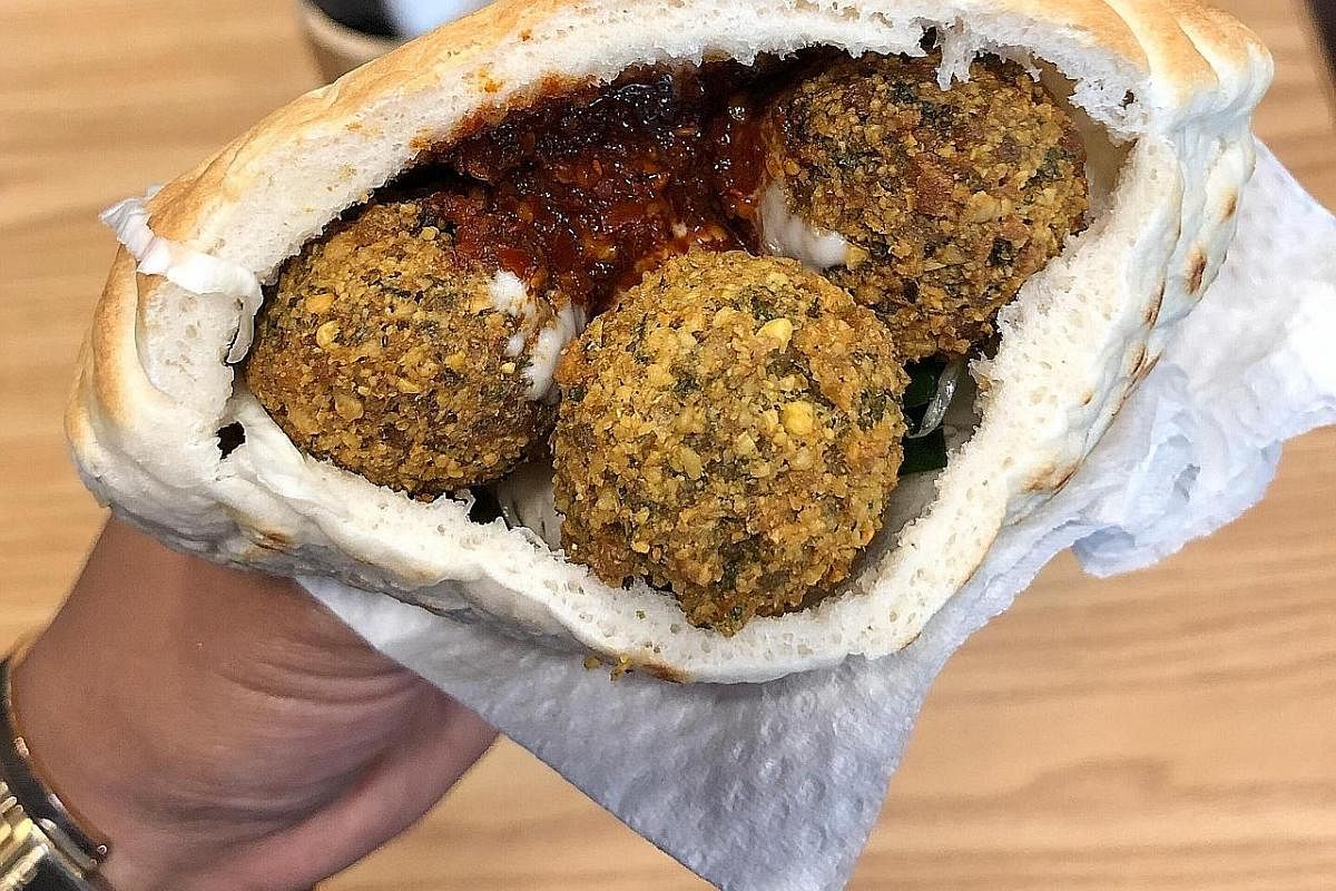 Pita pocket stuffed with falafel balls with pickled cabbage, tahini (ground, toasted sesame seeds) and harissa (hot chilli pepper paste).