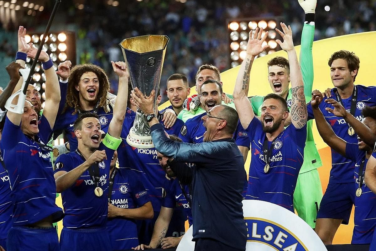 Chelsea's manager Maurizio Sarri lifts the Europa League trophy, his first major silverware as a coach, along with his jubilant team after they beat Arsenal in the final in Baku. Chelsea won 4-1 but the Italian's immediate future remains clouded by u