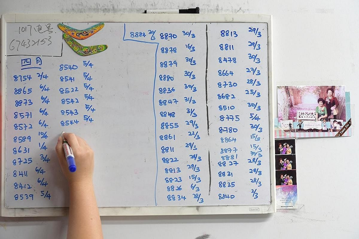 Ms Chua uses a whiteboard to help Madam Lie keep track of the customised orders (above), while Madam Lie takes a customer's measurements. Orders for Hari Raya can come in as early as six months before the festival.