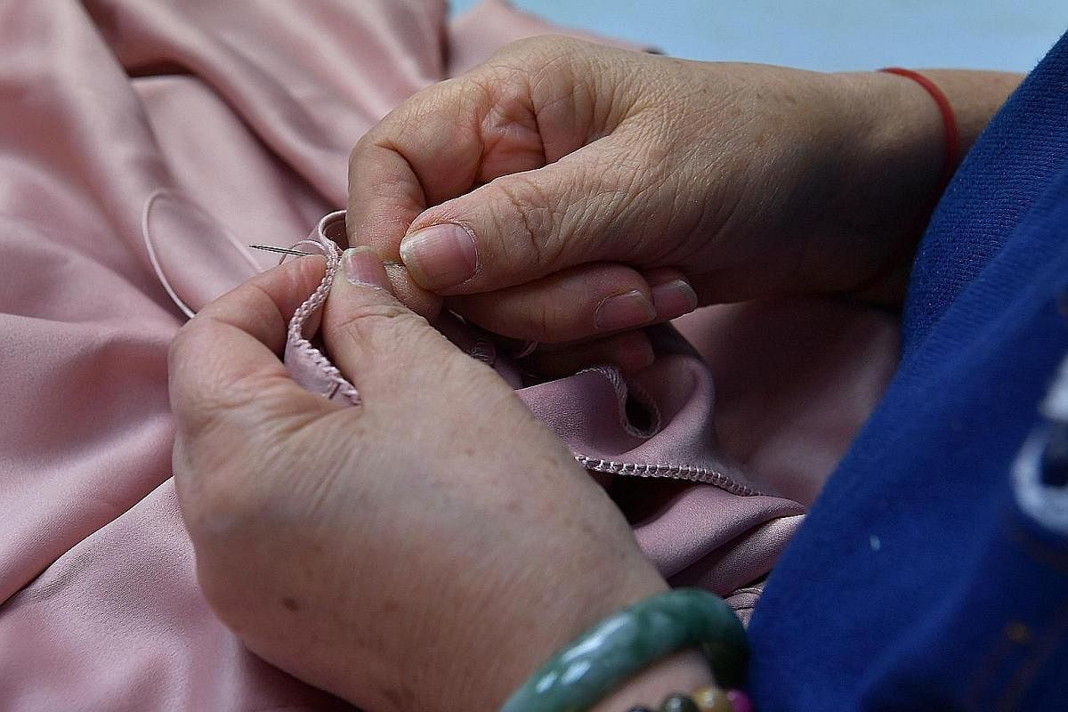 Seamstress Chen Liping sewing the traditional leher ketumbar design, a series of tiny knots sewn at the edge of the baju kurung collar to prevent fraying.