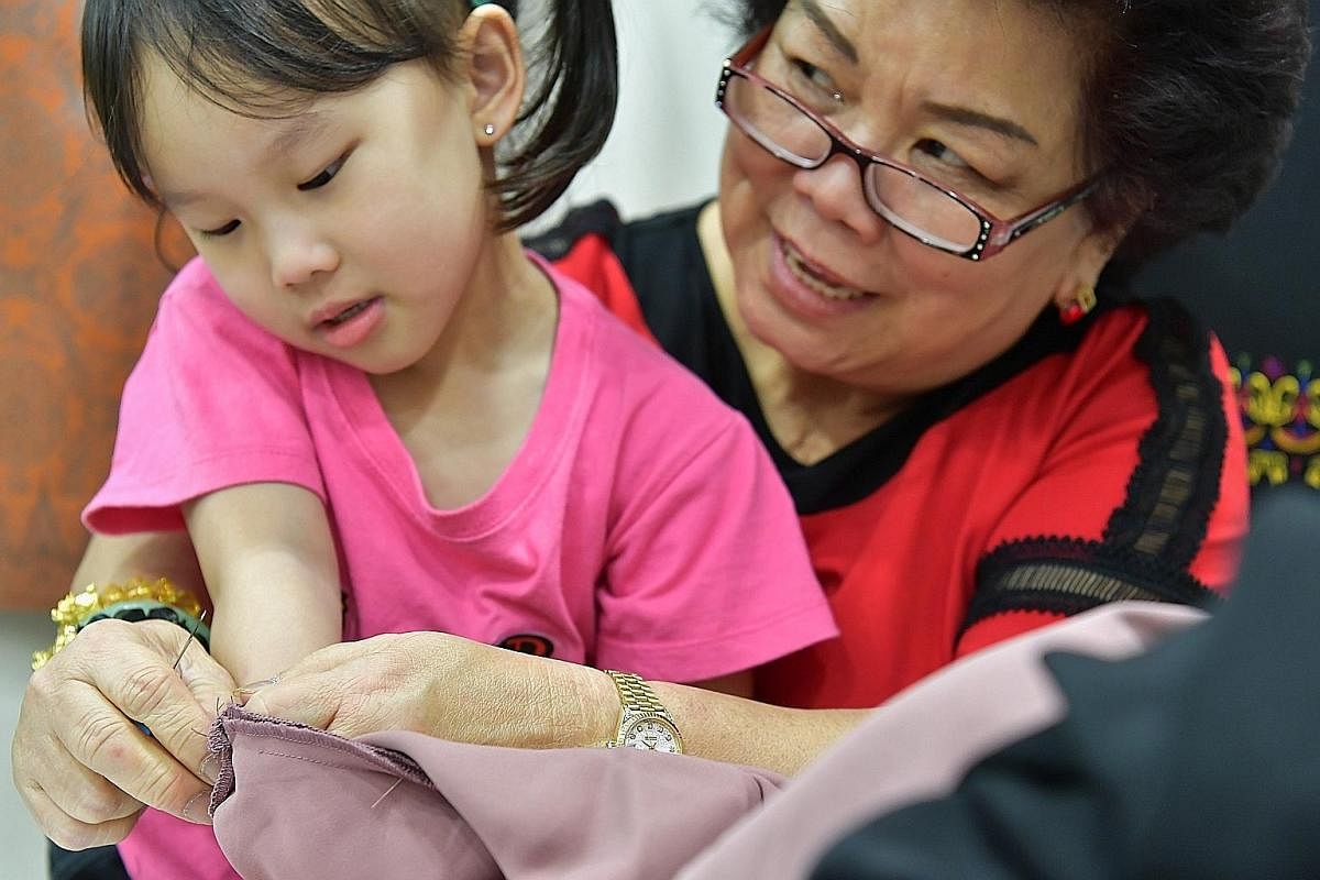 Madam Lie and her granddaughter Heidi Huang, five, who often visits the shop to watch her mother and granny at work.