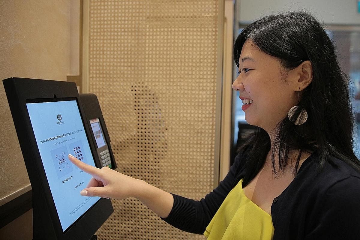 Straits Times tech video producer Bryan De Silva trying the self-check-in system at Swissotel The Stamford. (Left and below left) Straits Times tech correspondent Yip Wai Yee testing the facial recognition technology at coffee chain Old Town White Co