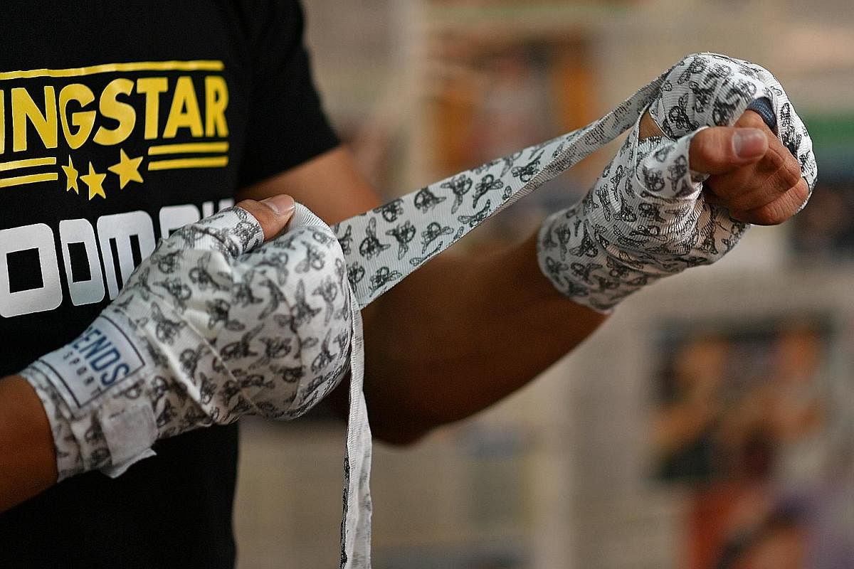 Ridhwan putting on his bee motif handwraps, which reflect boxing legend Muhammad Ali's famous quote: ''Float like a butterfly, sting like a bee."