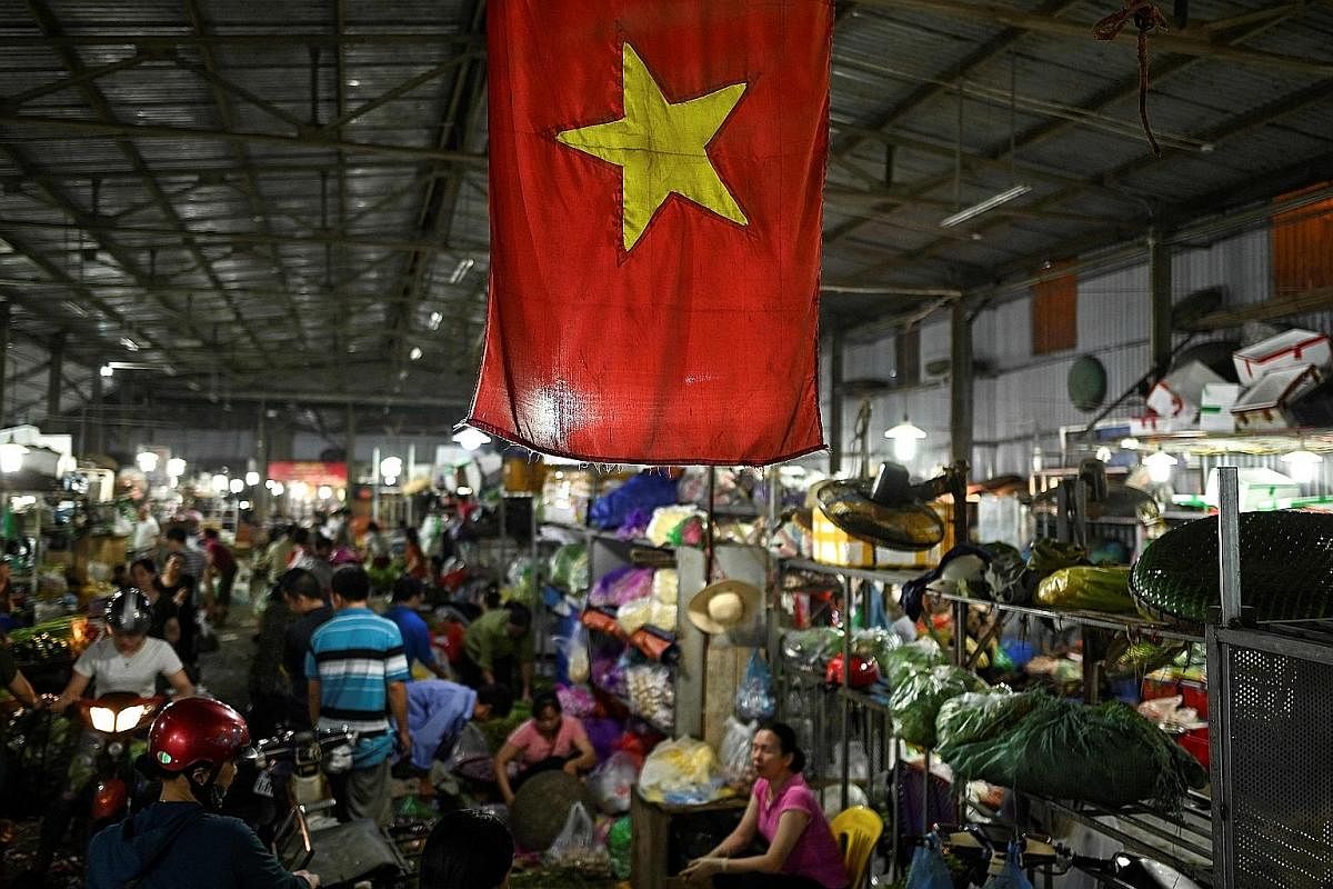Left: Women working at a Maxport garment factory in Thai Binh, a coastal province in the north, on June 13. Workers at a shoe factory in Dong Van Town, in northern Vietnam. Proximity to China, cheap labour, a raft of trade pacts and ongoing efforts t