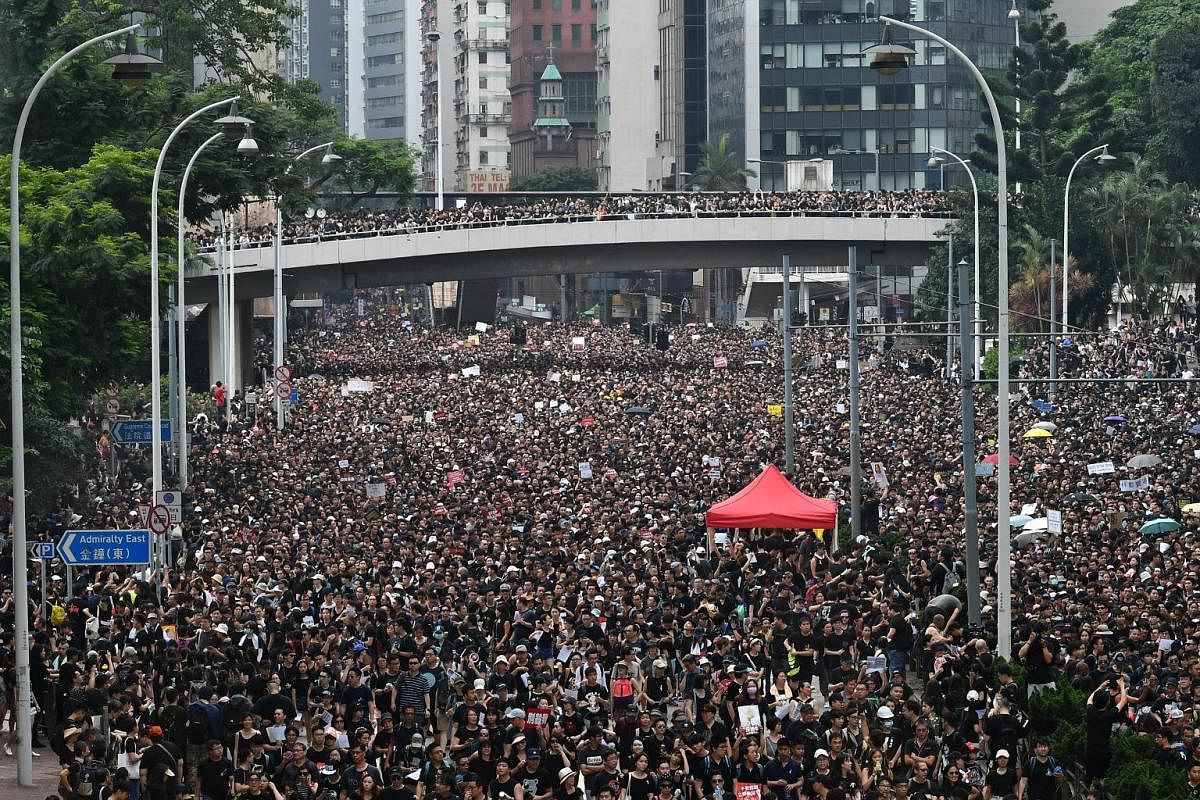 Protesters outside Victoria Park on Sunday. Demonstrators took to the streets demanding that the extradition Bill be completely scrapped, and for Chief Executive Carrie Lam to resign. A yellow jacket among bouquets of white flowers, written tributes 