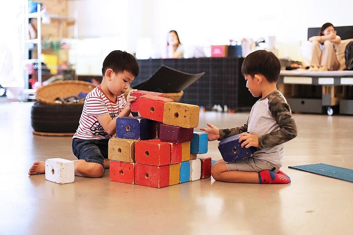 At Playeum, a children's centre for creativity, Eden Eyok (left), five, and Tan Hong Kai, six, can stack blocks or play with coloured tiles. Writer and researcher Hidayah Amin (centre, in black shirt) demonstrating sign language during an inclusive s