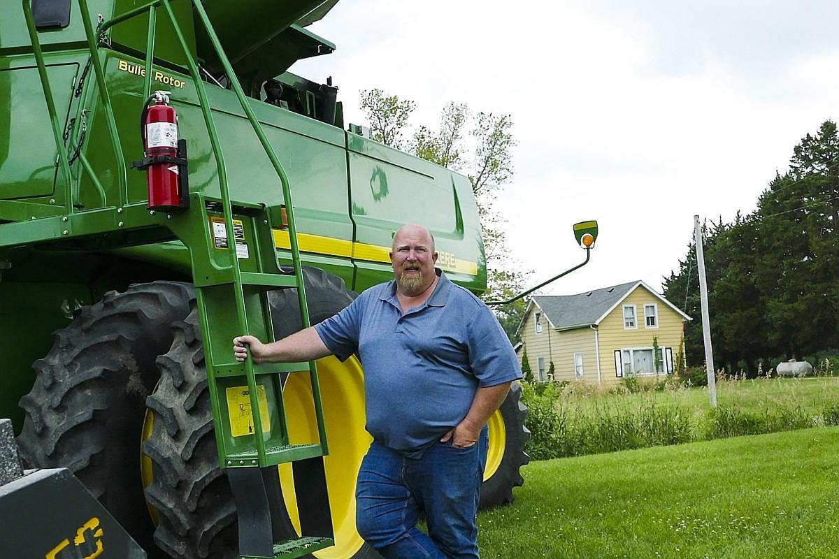 A farmer preparing cattle feed at his farm in Winthrop, Iowa. It is from states like Iowa that it becomes easier to understand how the Midwest views the country's capital and other liberal coastal cities. Above: Iowan farmer Dave Walton, who grows so