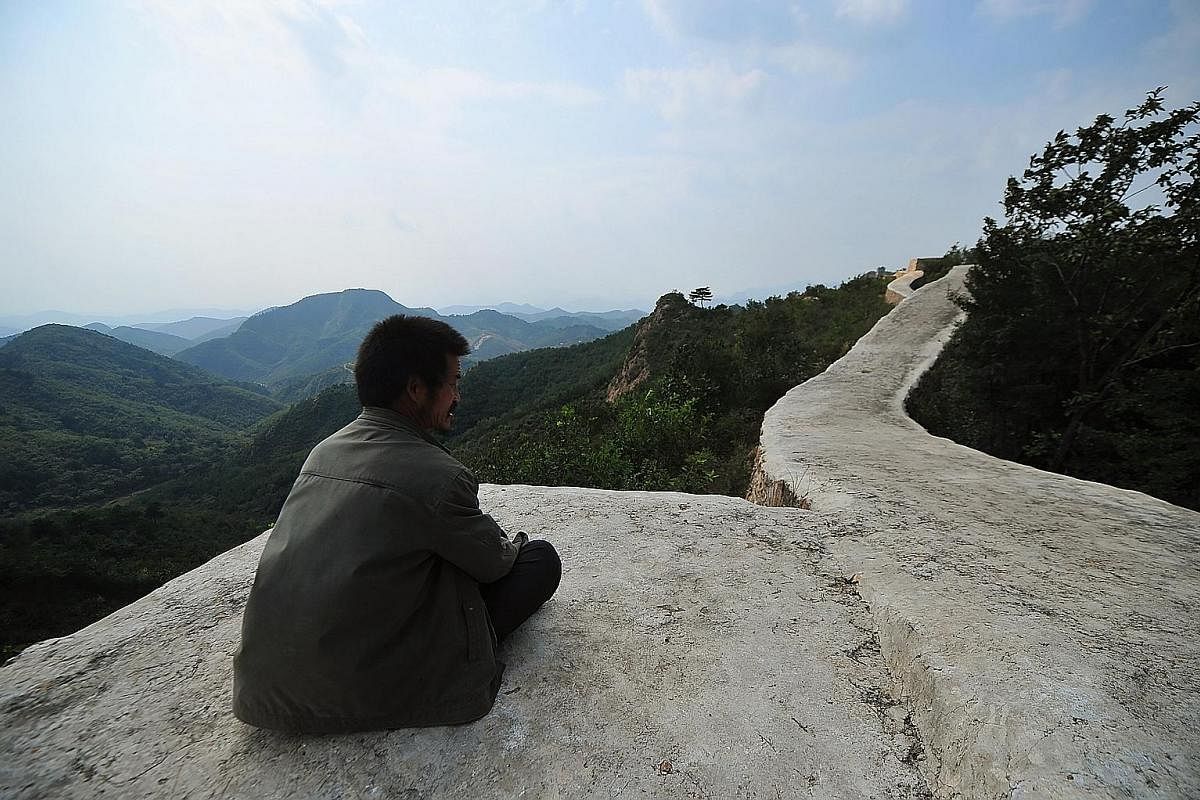 Right: A worker at part of the Great Wall in Xiangshuihu in Huairou district on the outskirts of Beijing on May 17. This year, Beijing launched a national-level plan to "guide restoration work", after criticism that shoddy work in the past had disfig