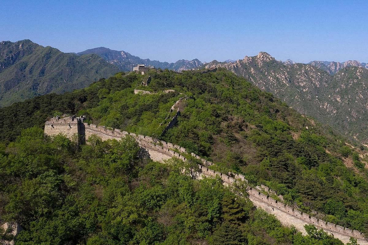 Right: A worker at part of the Great Wall in Xiangshuihu in Huairou district on the outskirts of Beijing on May 17. This year, Beijing launched a national-level plan to "guide restoration work", after criticism that shoddy work in the past had disfig