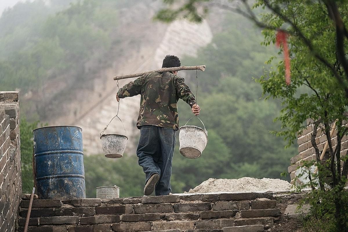 Apart from a motorised winch to lift old stone blocks, workers use basic tools like shovels and hammers, and bricks made using traditional methods. ST PHOTO: DANSON CHEONG