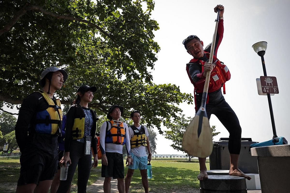 Left: A group of stand-up paddlers travelling along the south-eastern coast of Singapore. PAssion WaVe has groomed close to 390 paddlers since it launched the starter course in 2017. Above: Ms Jessica Wee taking a break during a paddle-and-pick sessi