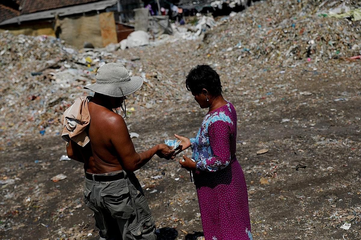 Left: Waste-picker Suparah of Sumengko village in Gresik, East Java, showing trash from a nearby paper factory. She earns about 50,000 rupiah (S$4.90) a day sorting garbage provided by her neighbour. Right: Yanti, a resident of Bangun village in Mojo