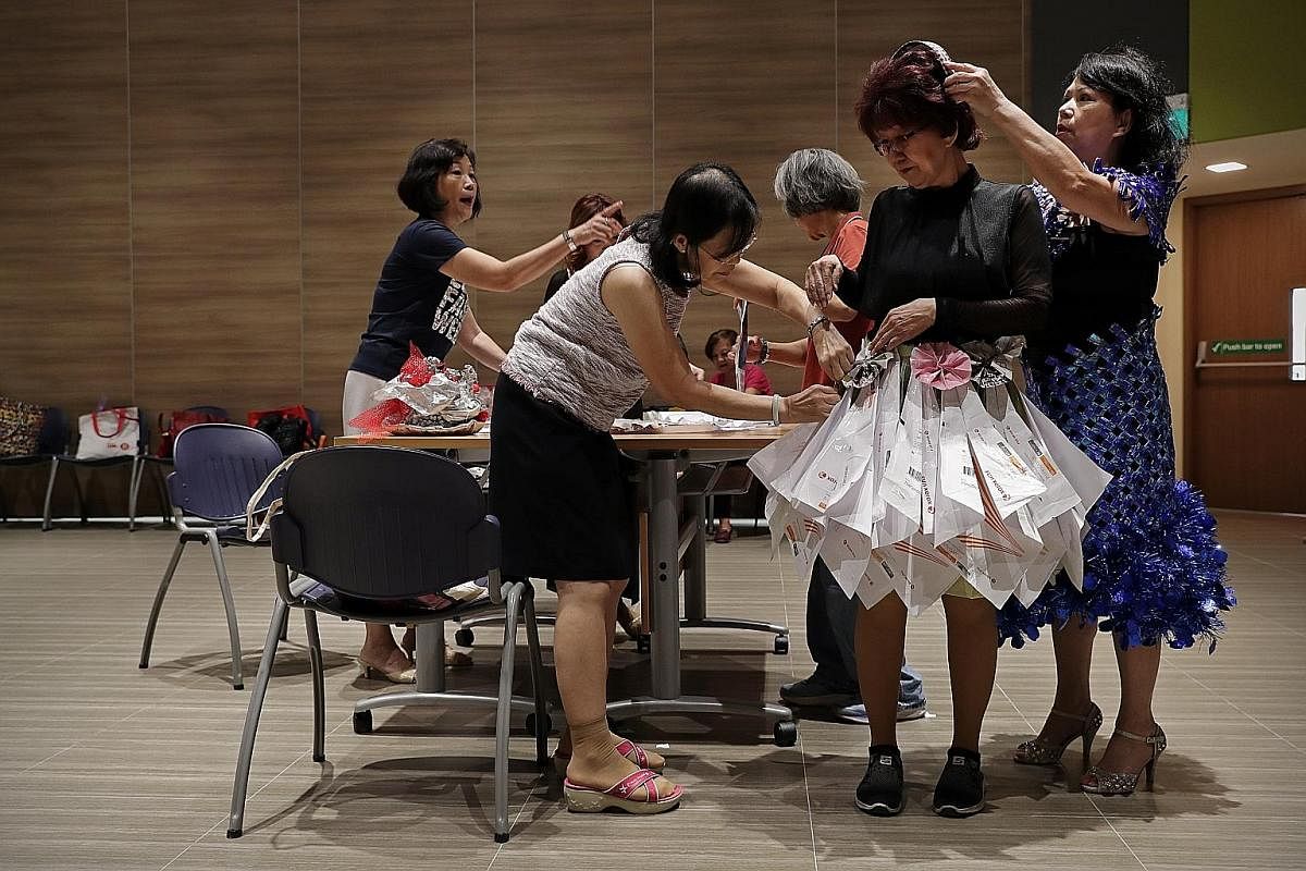 Housewife Lilian Lim (second from right) in a dress constructed from photocopying paper packaging. The packaging is folded and then stapled together to form the pleats of the dress. Madam Lim collected the packaging from a relative who works at a bookstor