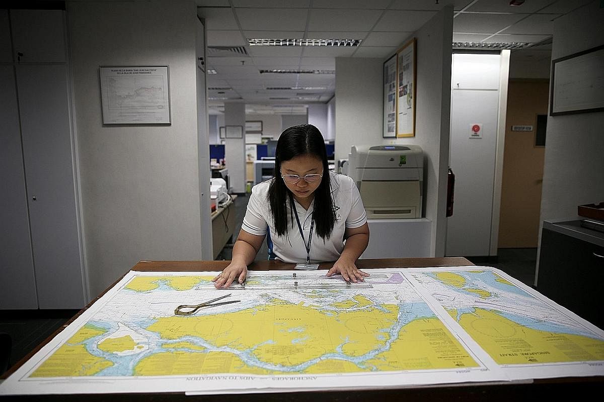 Left: Ms Siti Nursyahirah Sumsuri, technical executive (Cartography), checks a completed nautical chart with the aid of a parallel ruler.