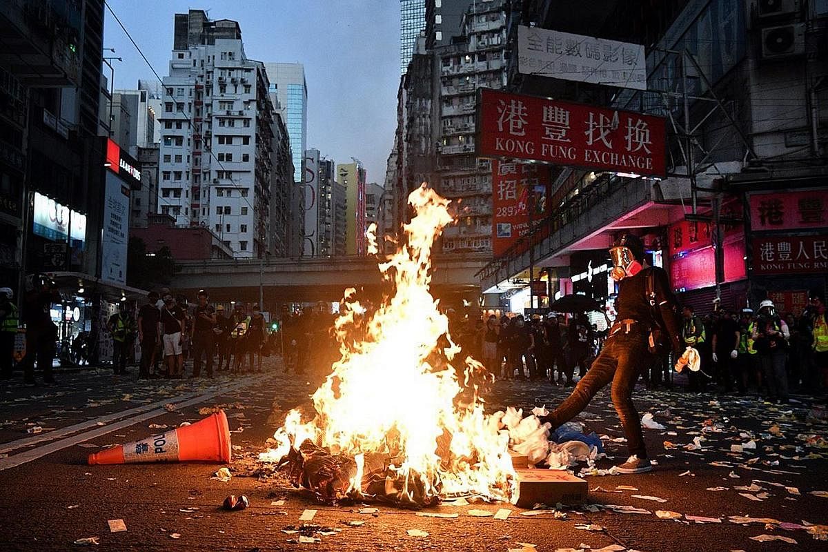 A protester using a fire extinguisher to slow down the police advance last month. Scenes of unprecedented violence have been broadcast constantly, sparking fears that this could normalise violence. Police firing tear gas at protesters from inside the