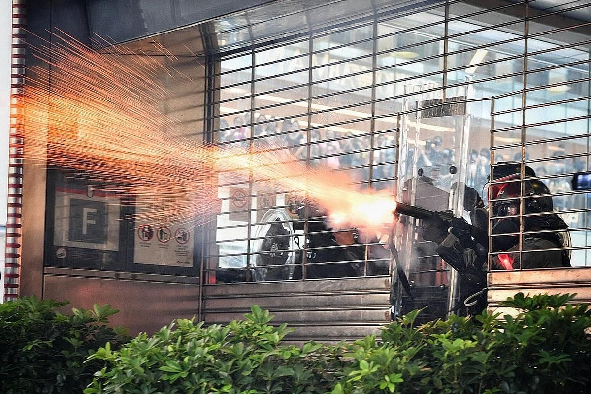 A protester using a fire extinguisher to slow down the police advance last month. Scenes of unprecedented violence have been broadcast constantly, sparking fears that this could normalise violence. Police firing tear gas at protesters from inside the