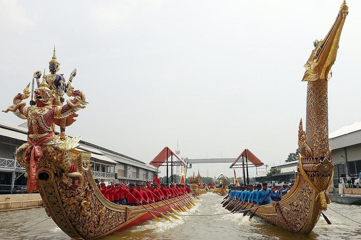 A close-up view of part of the royal barge, displayed at the Royal Thai Dockyard Museum in Bangkok. The King and Queen will be aboard a shimmering barge called Suphannahong (right), which has a bow shaped like a swan's head. On the left is another ro