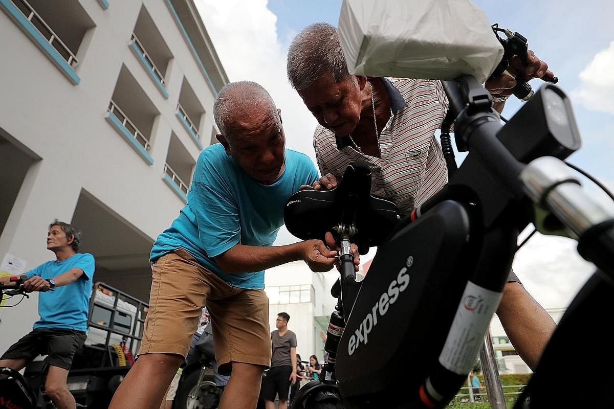 Mr Shawn Tan (front) and Mr Khairul dismantling e-scooters at their workstation in Virogreen's warehouse in Tuas. Each of them dismantles about 20 PMDs a day. The long queue at a designated e-scooter disposal point at a multi-storey carpark behind Na