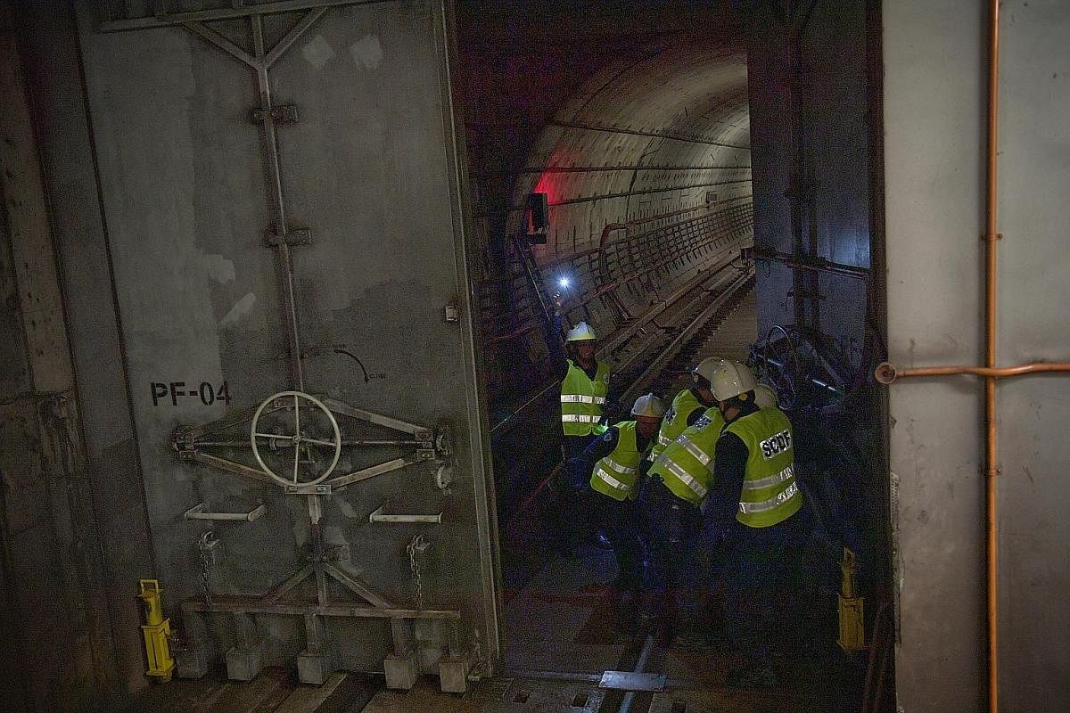 The servicemen closing the reinforced steel blast doors at an MRT track tunnel entrance during the exercise at Bishan MRT Civil Defence Shelter (Circle Line) in the early hours of Dec 10 last year.