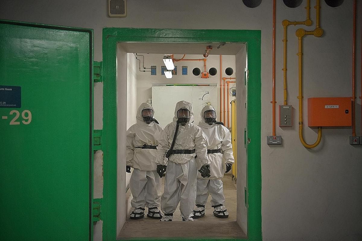 Hazmat – hazardous materials – suits are donned by servicemen manning the decontamination chamber.