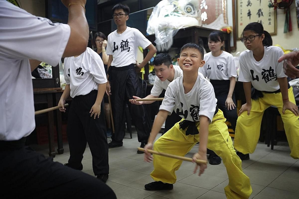 Troupe leader Lui Kai Keong coaching young members (from left) Rovin Ng, Ronald Ng and Seah Kia Wee in basic martial arts moves. As lion dance is closely linked with martial arts, practitioners must master basic martial arts skills to become good lio