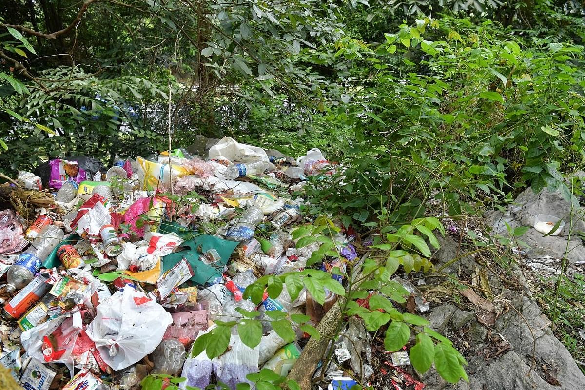 Far left: The men from the forest congregate in the evenings at the Petir Road and Bangkit Road HDB estates and receive big plastic bags of items. The contents are redistributed and packed into smaller plastic bags. The men disperse while another cyc