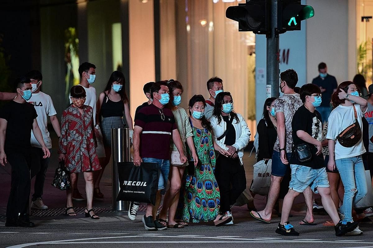 Pedestrians outside The Heeren shopping centre in Orchard Road on Tuesday. Retailers are hoping online vouchers and flash deals will not only boost sales, but also help drive shoppers back to their physical stores.